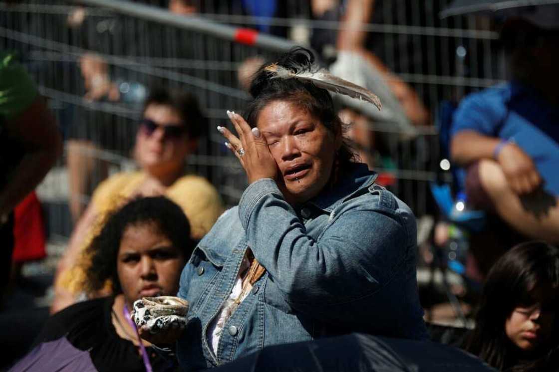 An Indigenous woman cries as Catholic faithful listen to Pope Francis celebrate mass inside the shrine of Sainte-Anne-de-Beaupre in Quebec, Canada, on July 28, 2022