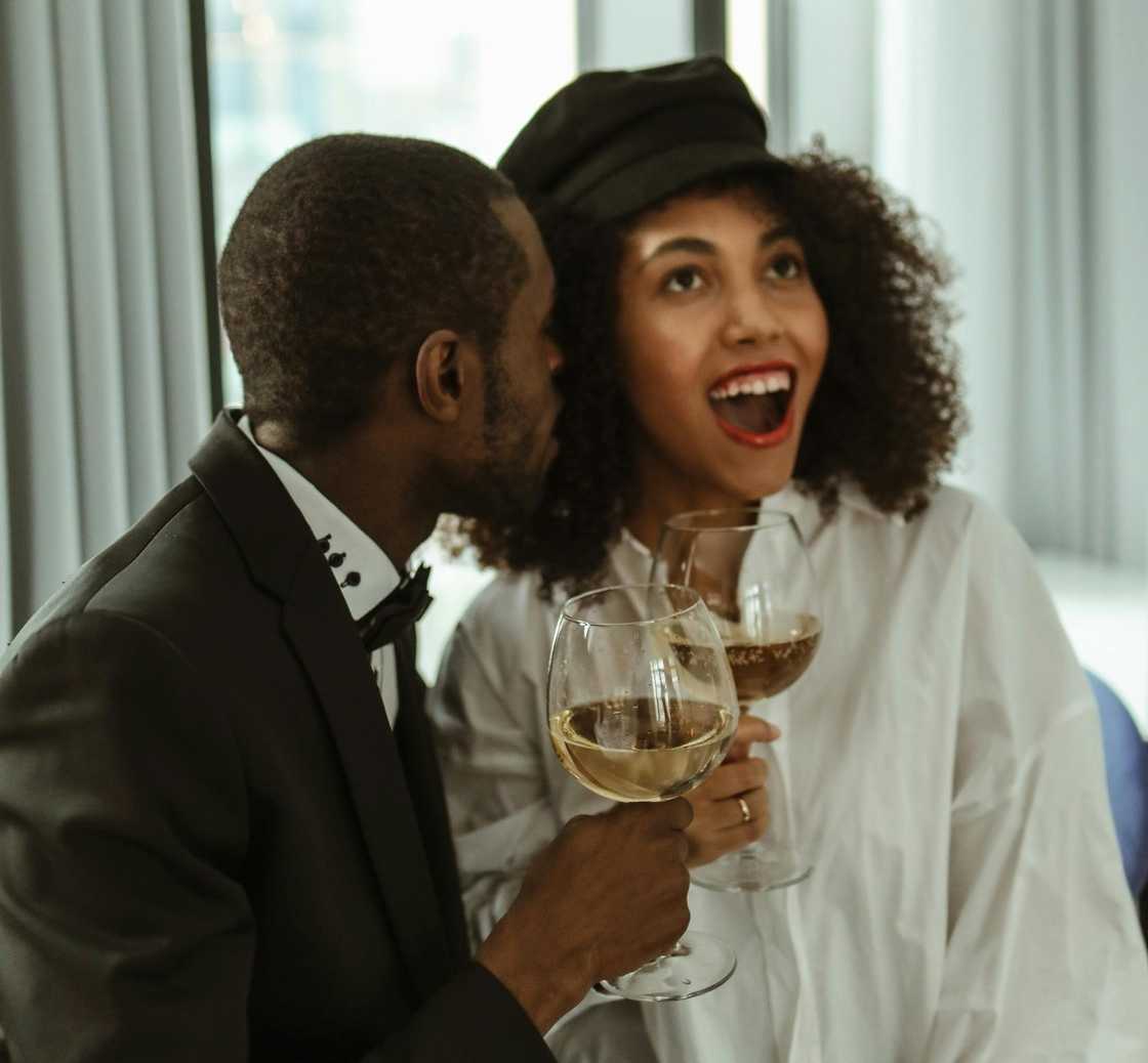 A man whispering to his wife A man whispering to his wife