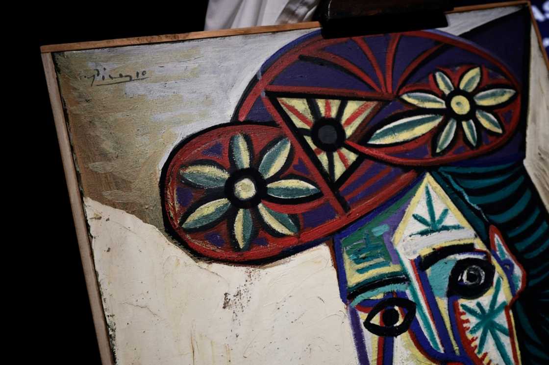 The painting is in a simple wooden frame The painting is in a simple wooden frame
