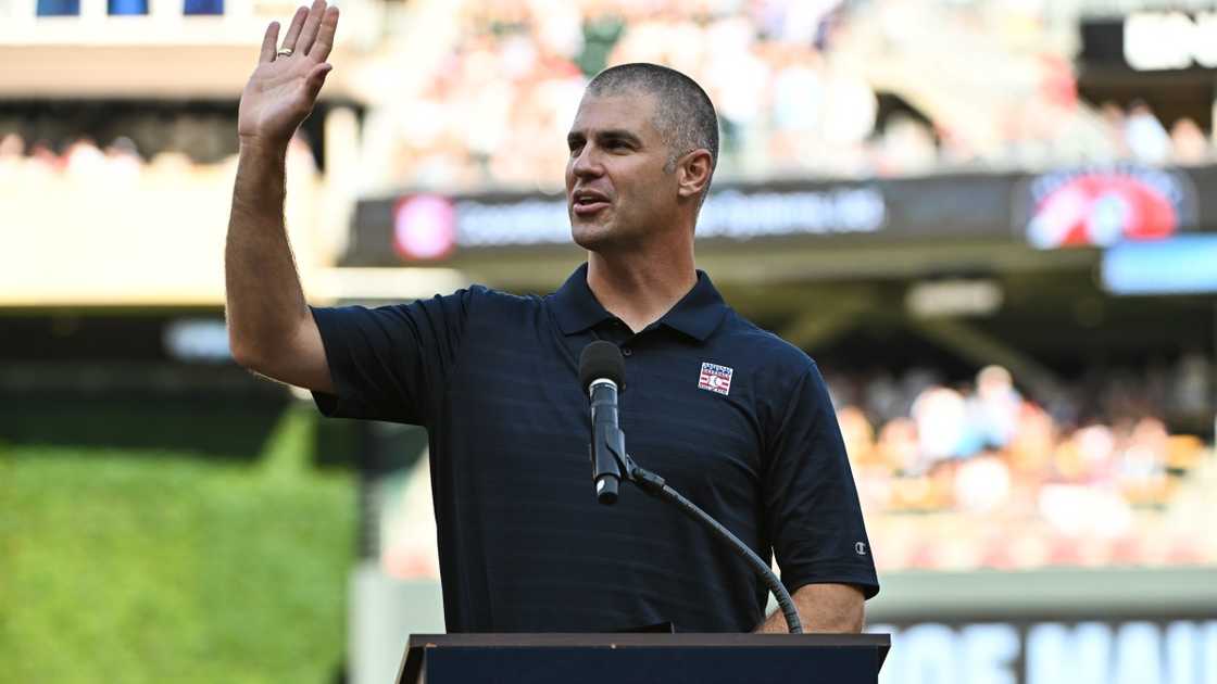 Former Minnesota Twins player Joe Mauer addresses fans on a podium.