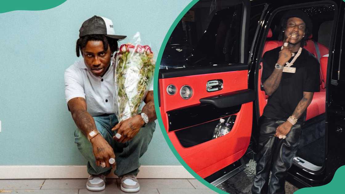 Shallipopi in front of a pale blue wall and standing next to a car Shallipopi in front of a pale blue wall and standing next to a car