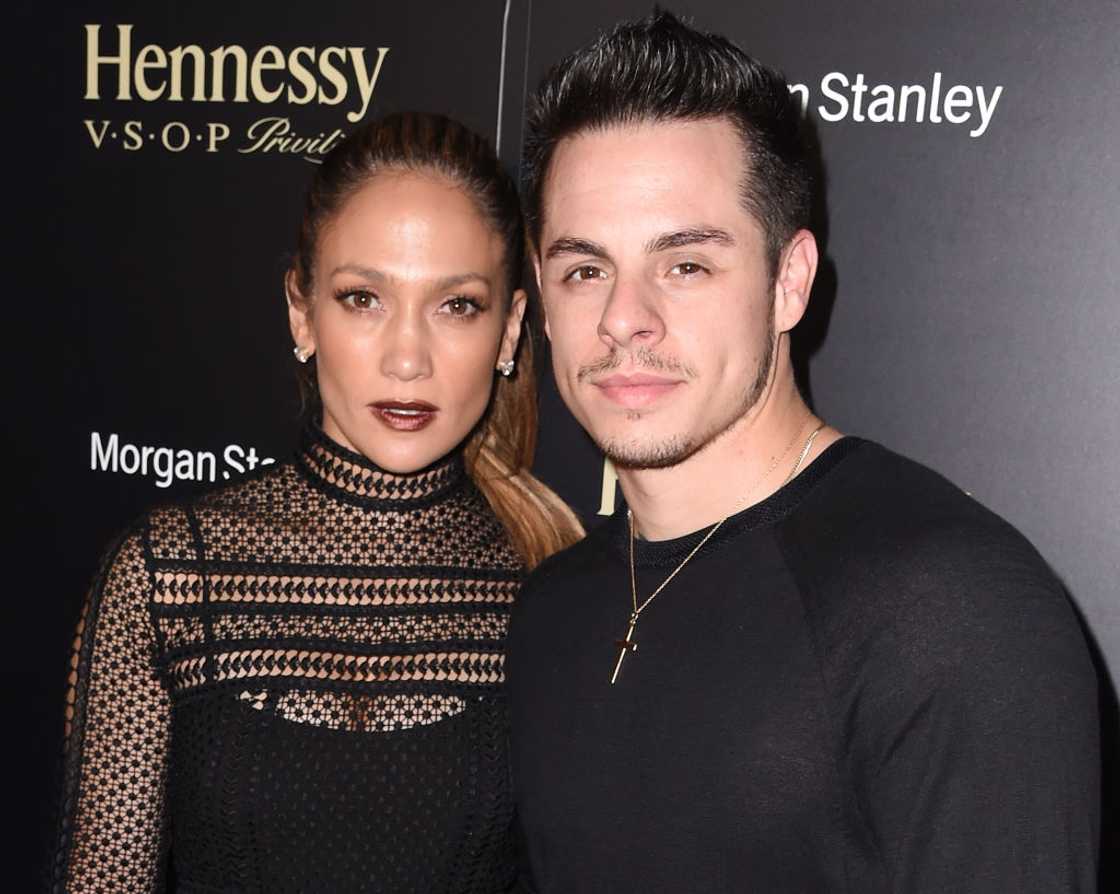 Jennifer Lopez in a black lace top beside Casper Smart in a black sweater with a cross necklace. Jennifer Lopez in a black lace top beside Casper Smart in a black sweater with a cross necklace.