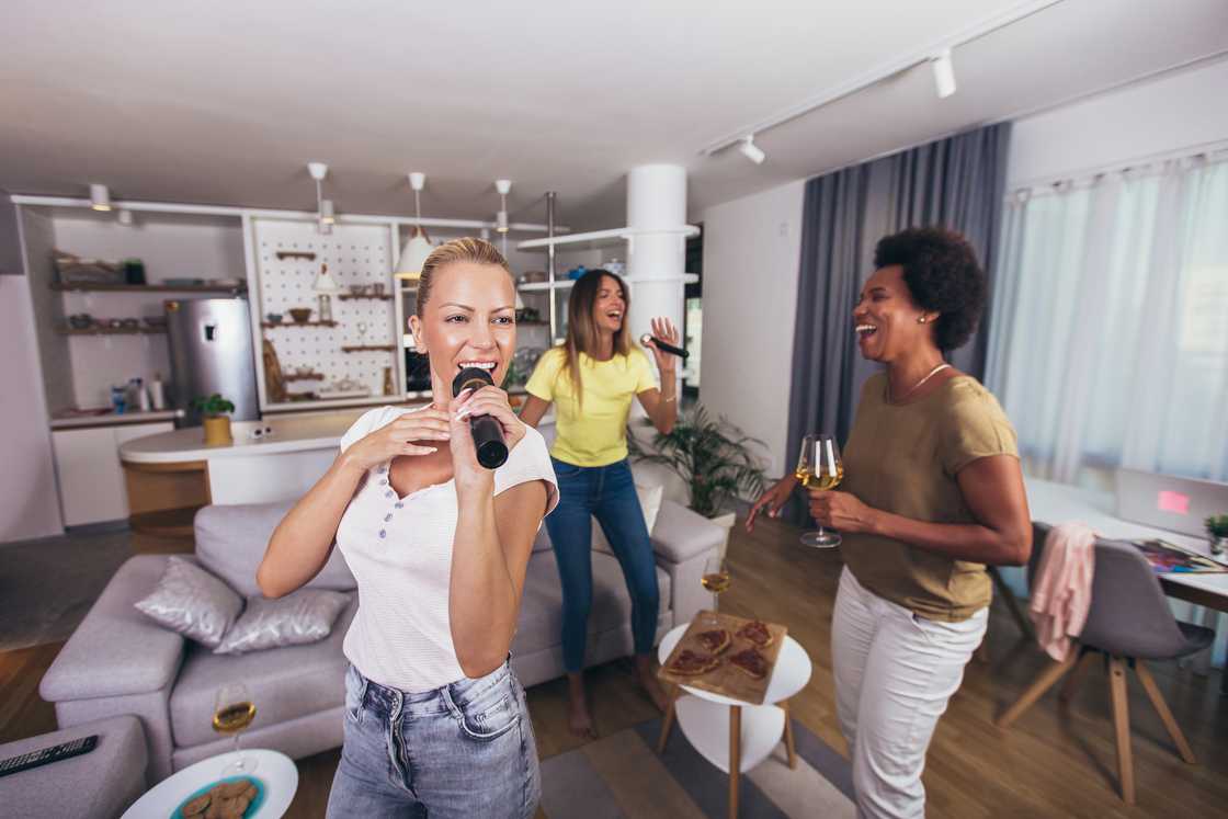 Group of young women spend time in karaoke at home