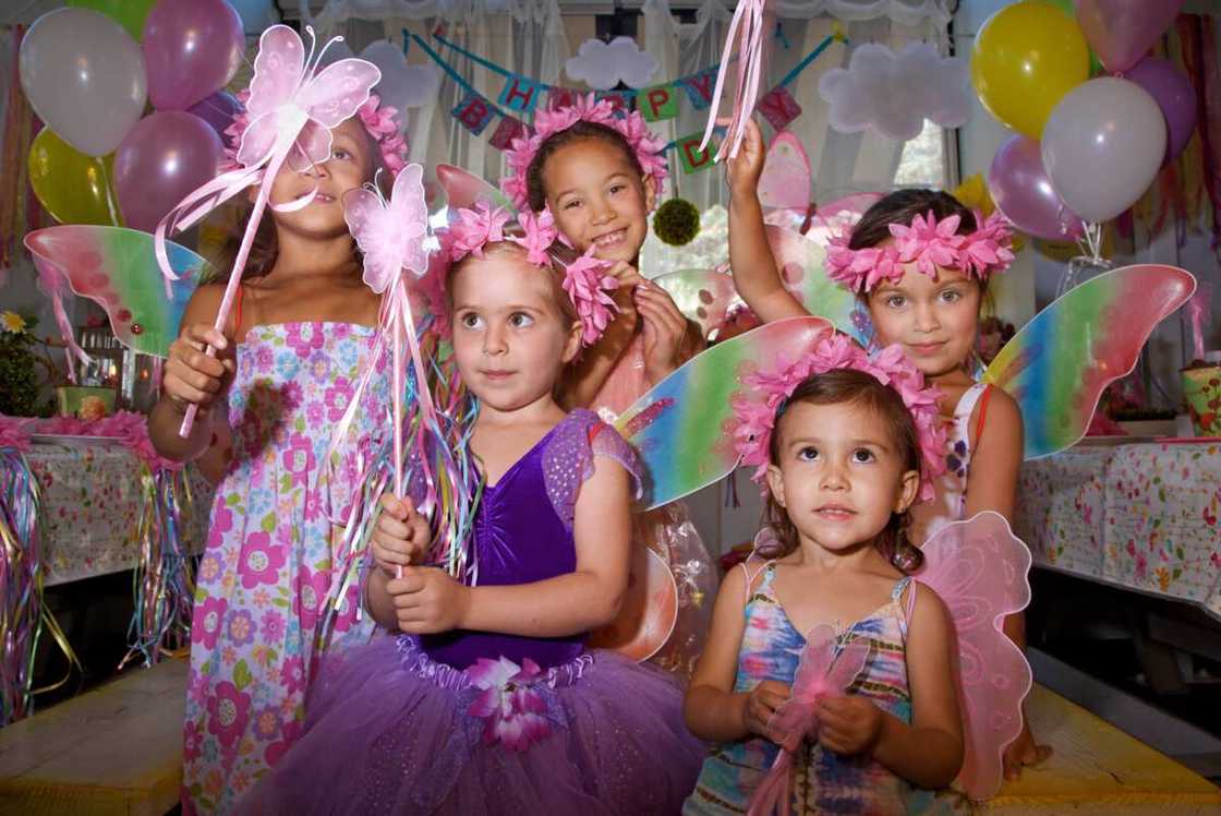 Lttle girls pose as butterfly princesses at a costume-themed birthday party