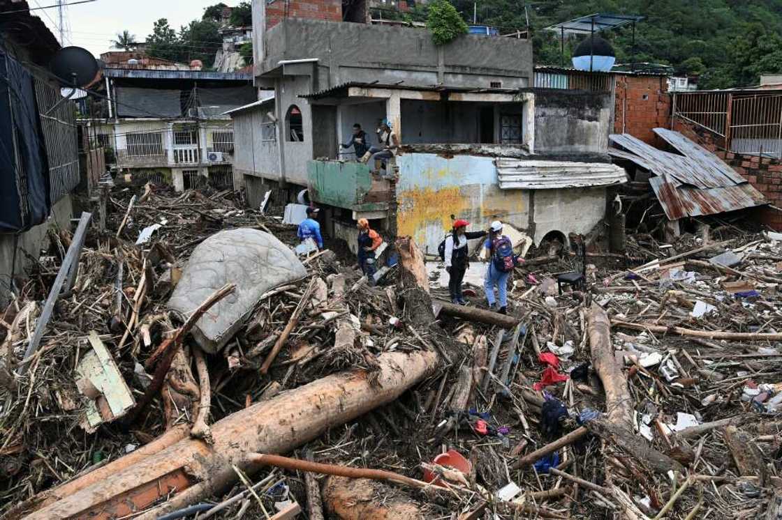 Rescuers and residents search through the rubble of destroyed houses for victims or survivors of a landslide during heavy rains in Las Tejerias, Venezuela, on October 9, 2022 Rescuers and residents search through the rubble of destroyed houses for victims or survivors of a landslide during heavy rains in Las Tejerias, Venezuela, on October 9, 2022