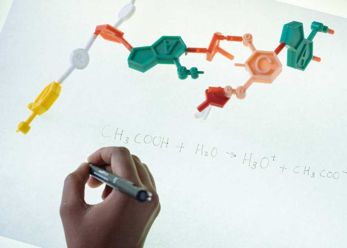 A student writing formula after analysis of molecule model in university