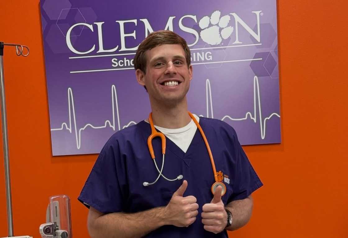 Tanner Smith poses in nursing scrubs