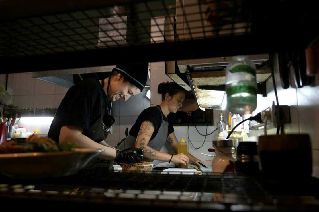 Agustina Bovi (L) cooks at the small vegan restaurant 'Yedra,' in Buenos Aires, but even with another job on the side she's living through her 'worst period from an economic point of view'