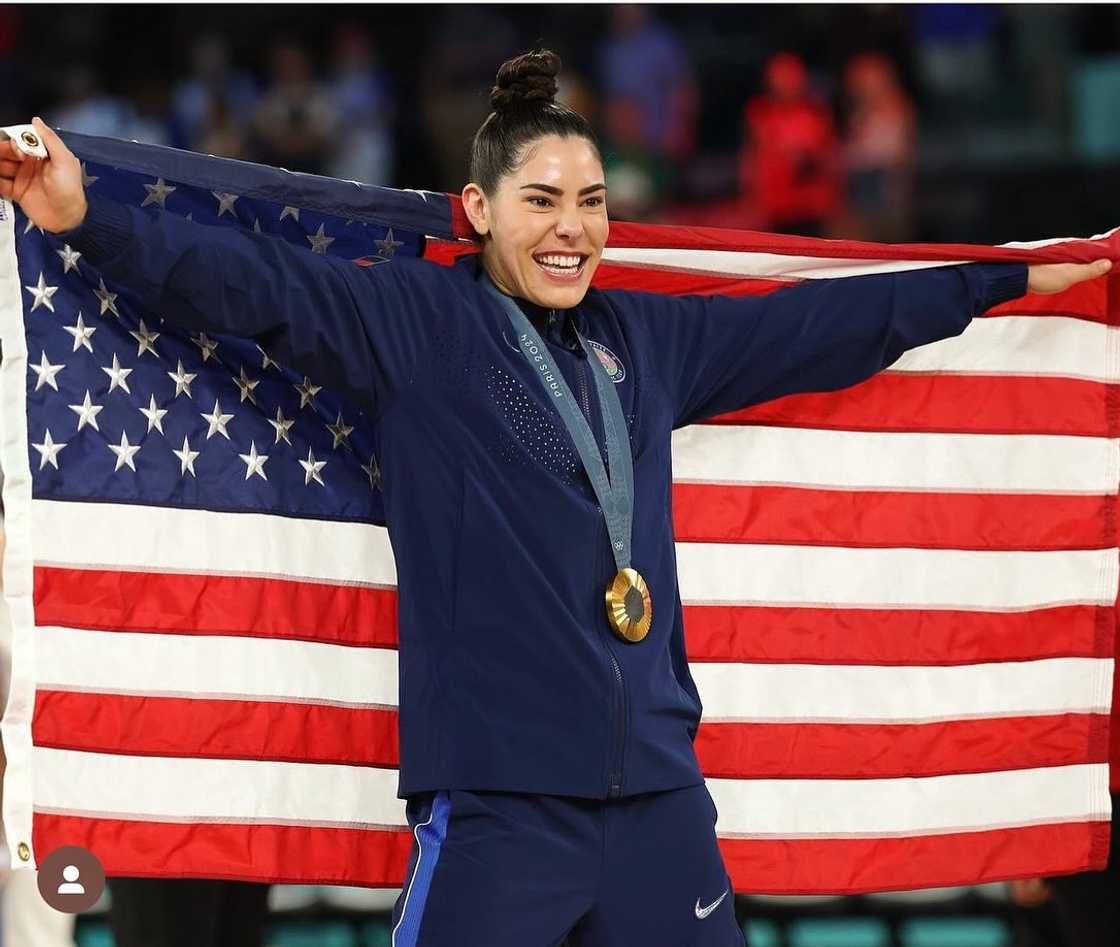 Kelsey Plum wearing a medal and holding the American flag at the Olympics Kelsey Plum wearing a medal and holding the American flag at the Olympics