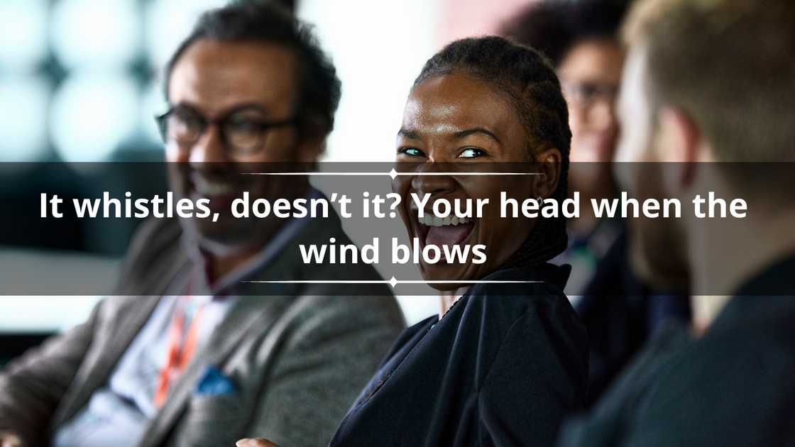 Two men and women in an office setting laughing Two men and women in an office setting laughing