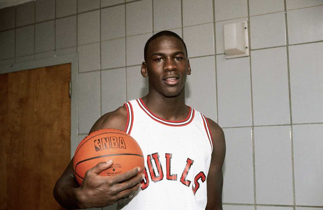 Michael Jordan holding a basketball in the locker room