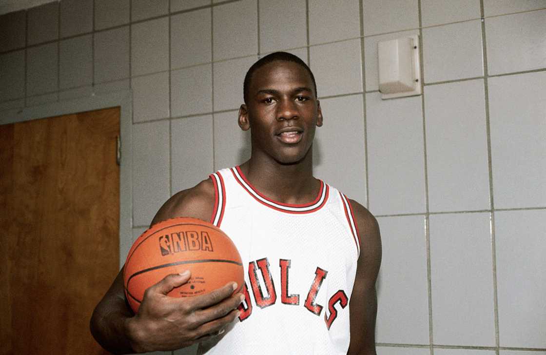 Michael Jordan holding a basketball in the locker room Michael Jordan holding a basketball in the locker room