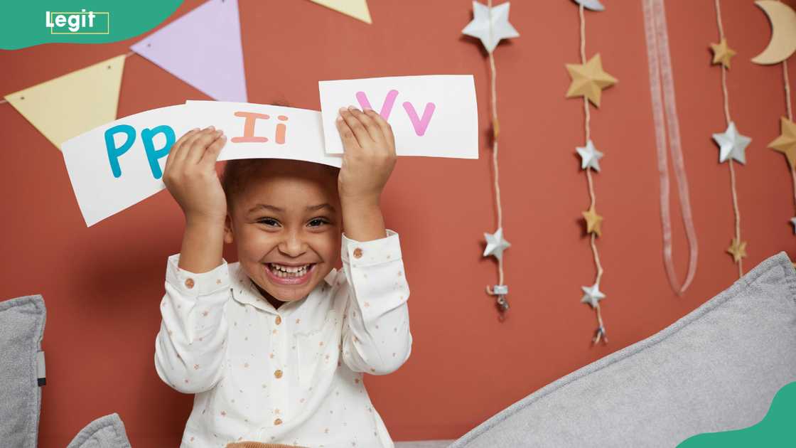 A cheerful girl holding letter cards