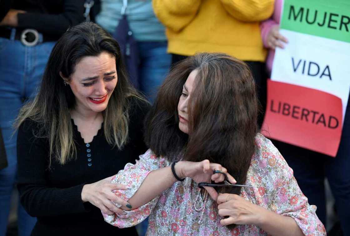 A protester cries as another cuts her hairs during a demonstration in support of Kurdish woman Mahsa Amini in Madrid A protester cries as another cuts her hairs during a demonstration in support of Kurdish woman Mahsa Amini in Madrid