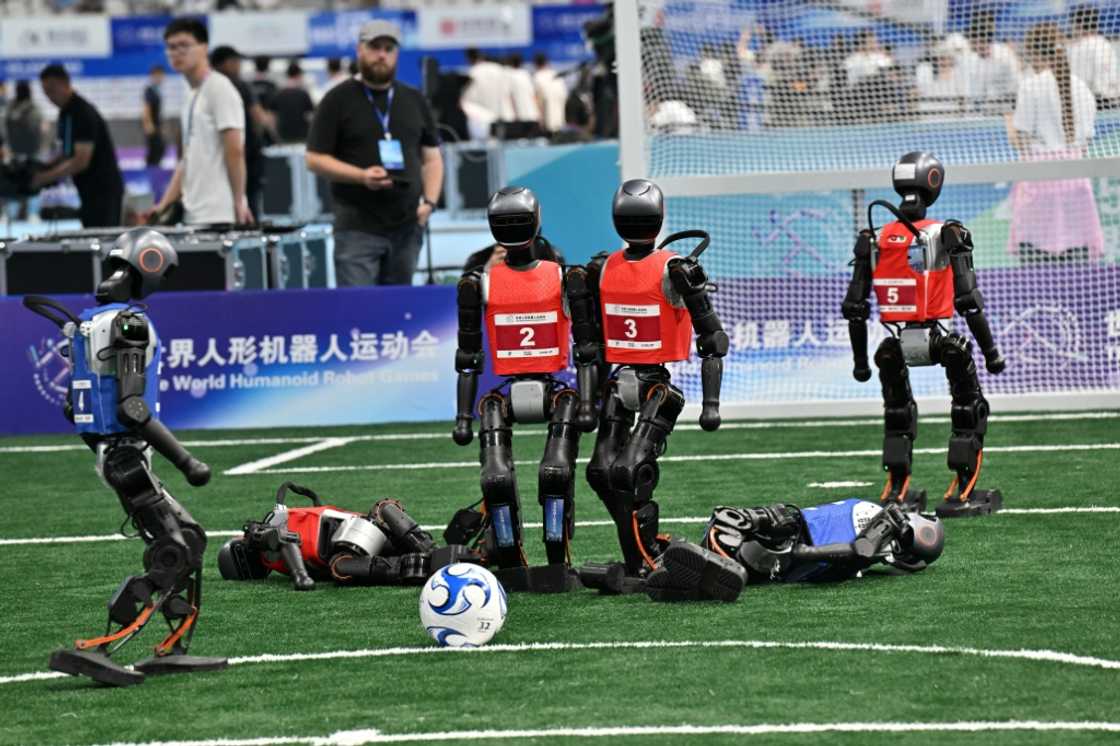 Robots compete in a 5x5 football match during the World Humanoid Robot Games. Falling over was a frequent occurrence Robots compete in a 5x5 football match during the World Humanoid Robot Games. Falling over was a frequent occurrence