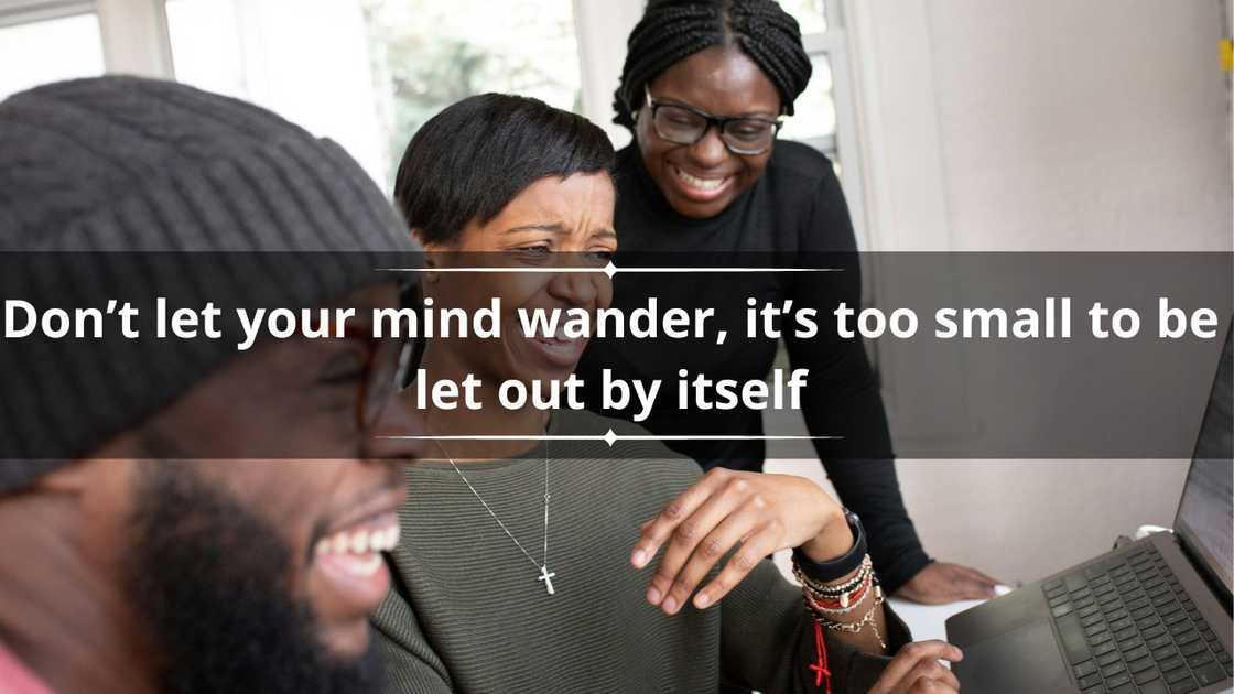 Three people laughing at something on the screen of a laptop Three people laughing at something on the screen of a laptop