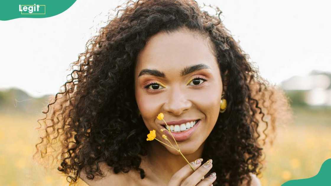 A woman smelling a yellow flower