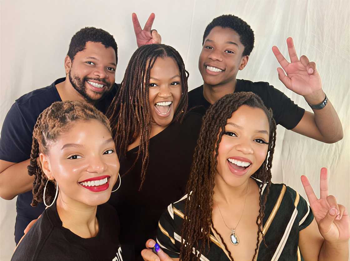 Halle and Chloe Bailey with their parents and brother posing for a photo