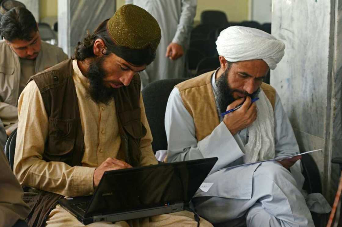 Taliban member Gul Agha Jalali (L) is one of many fighters who have traded combat for the classroom following the group's return to power