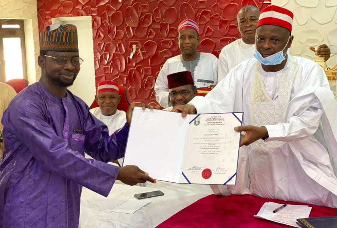 Kwankwaso handing a certificate to an awardee Kwankwaso handing a certificate to an awardee