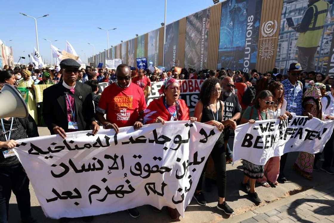 The sister of jailed Egyptian activist Alaa Abdel Fattah, Sanaa Seif (fourth from left), was at the front of the protest for climate justice and human rights