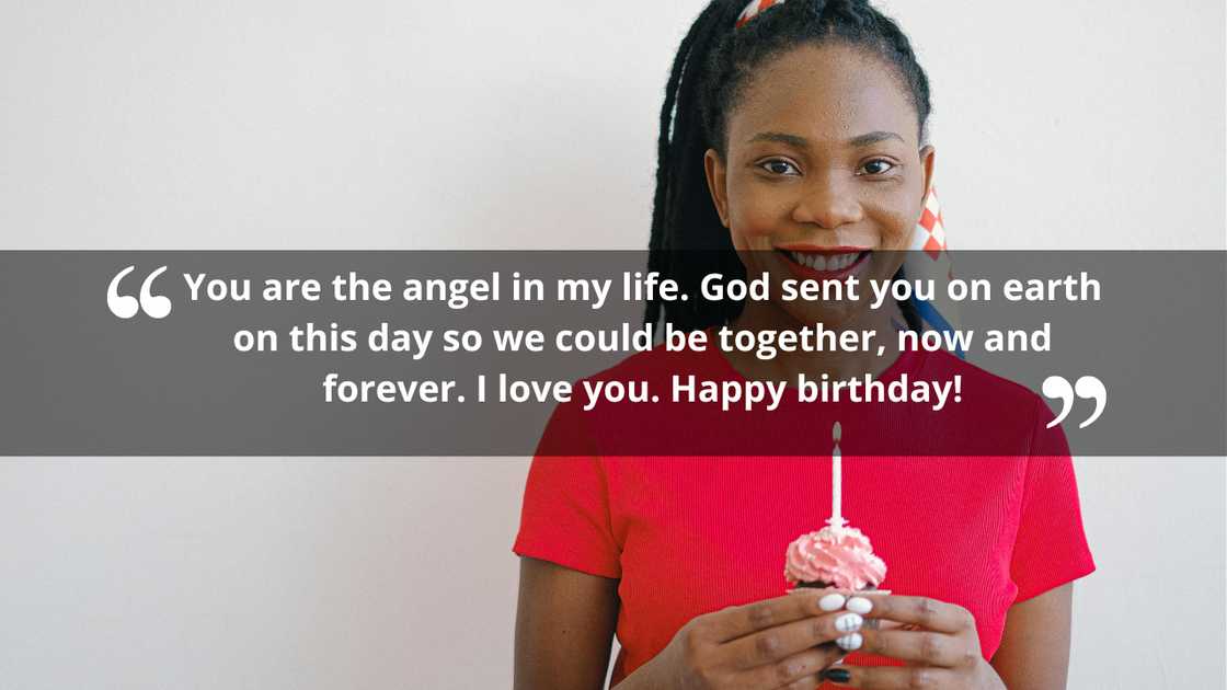 A woman celebrating her birthday holding a cupcake with a candle smiling A woman celebrating her birthday holding a cupcake with a candle smiling