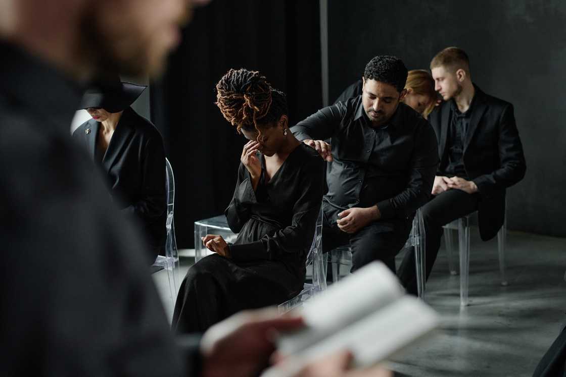 Shocked faces of mourners during a funeral service.