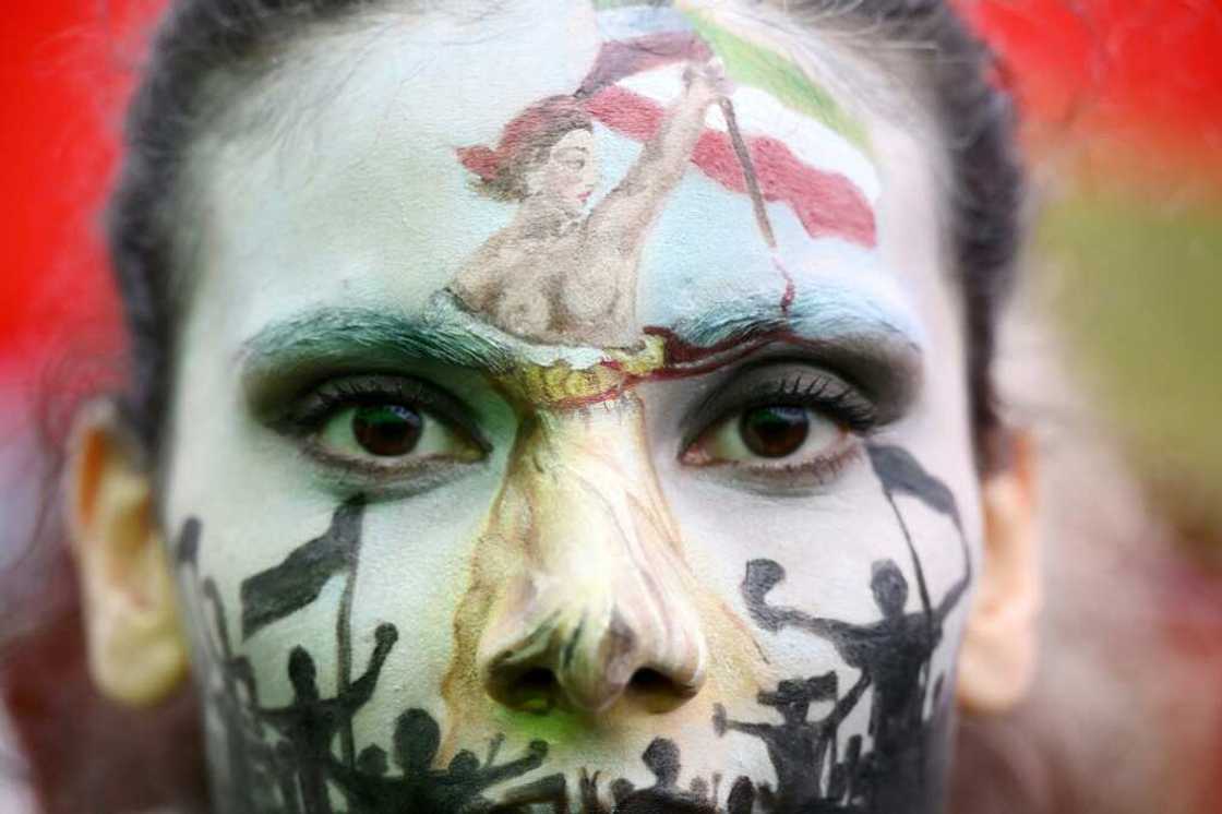 A protester wearing face-paint depicting France's iconic "Marianne" leading an uprising, attends a demonstration in support of Kurdish woman Mahsa Amini on October 2 in Paris A protester wearing face-paint depicting France's iconic "Marianne" leading an uprising, attends a demonstration in support of Kurdish woman Mahsa Amini on October 2 in Paris
