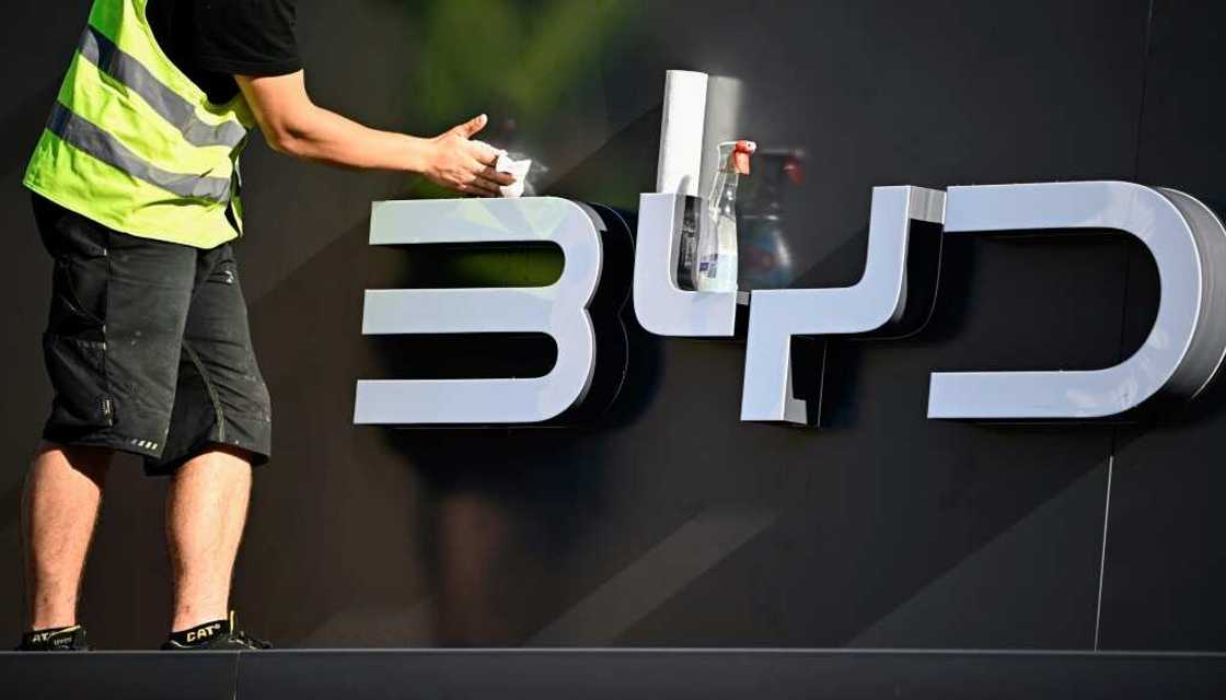 A worker cleans the company logo of Chinese carmaker BYD at their booth before the official launch of the International Motor Show (IAA) in the center of Munich, southern Germany, on September 4, 2023 A worker cleans the company logo of Chinese carmaker BYD at their booth before the official launch of the International Motor Show (IAA) in the center of Munich, southern Germany, on September 4, 2023