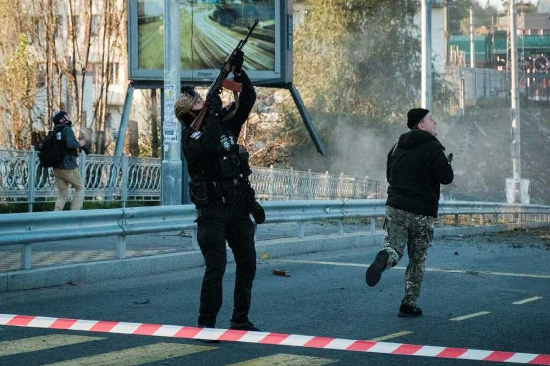 A police officer fires at a flying drone following attacks in Kyiv on October 17, 2022, amid the Russian invasion A police officer fires at a flying drone following attacks in Kyiv on October 17, 2022, amid the Russian invasion