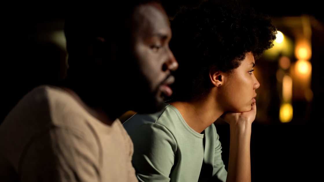 A worried couple in a dark room A worried couple in a dark room