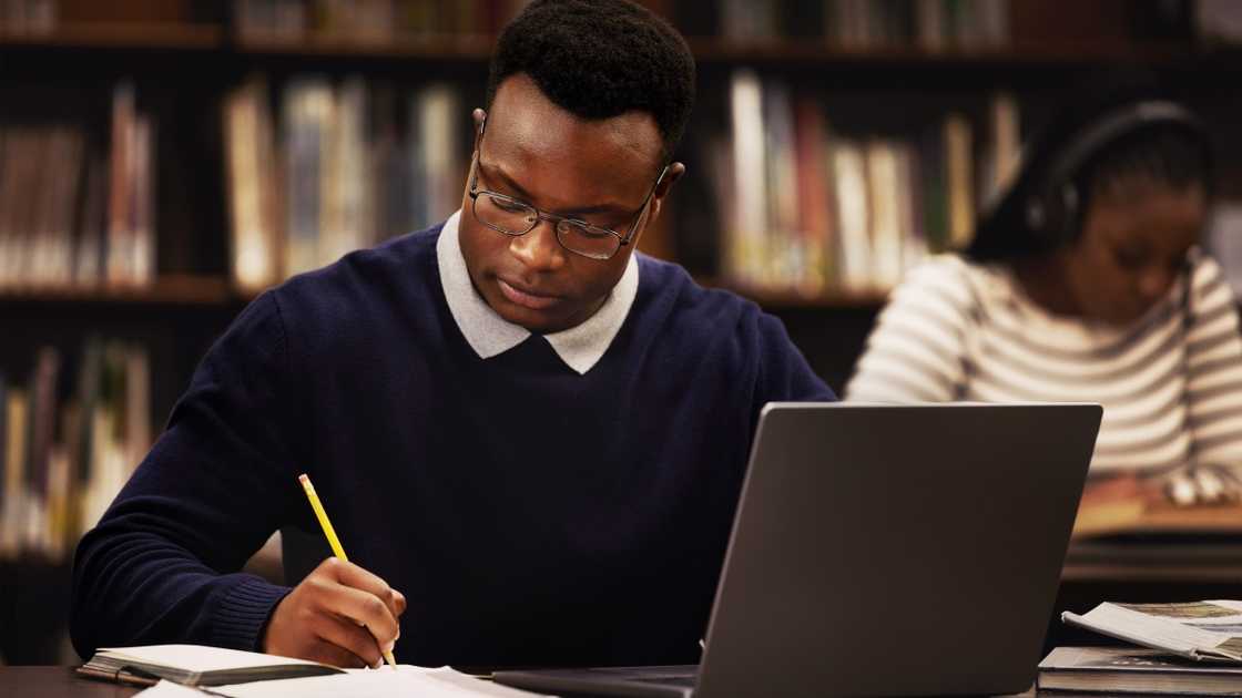 A student is pictured studying in a library. A student is pictured studying in a library.