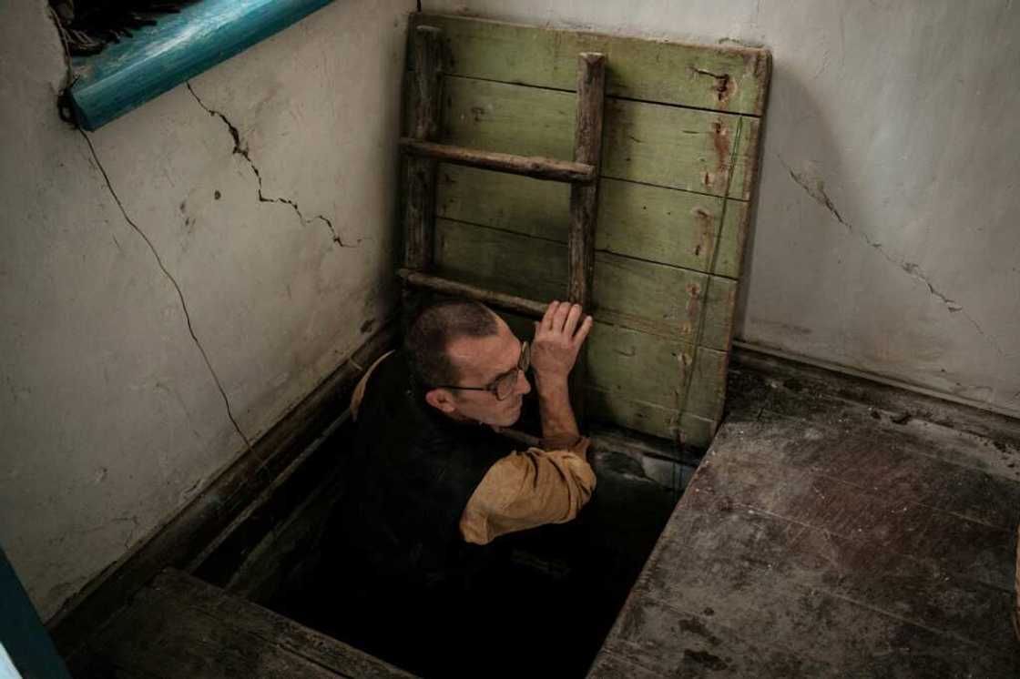 Ivan Lobachov emerges from a cellar used as a shelter, in the family house which was partially destroyed by shelling Ivan Lobachov emerges from a cellar used as a shelter, in the family house which was partially destroyed by shelling