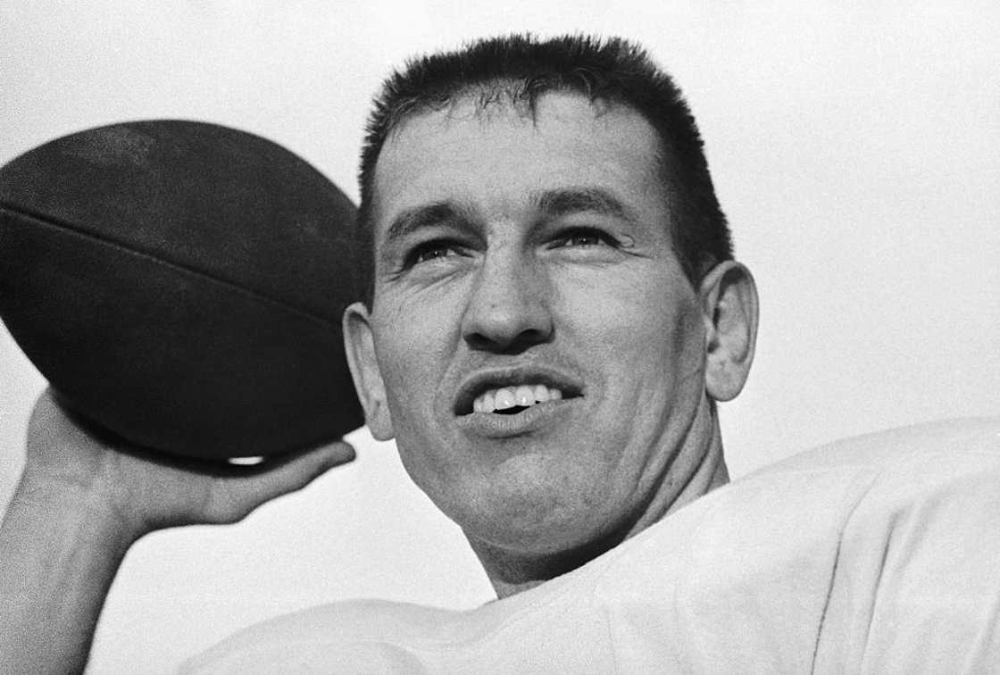 Johnny Unitas smiles while hold a ball