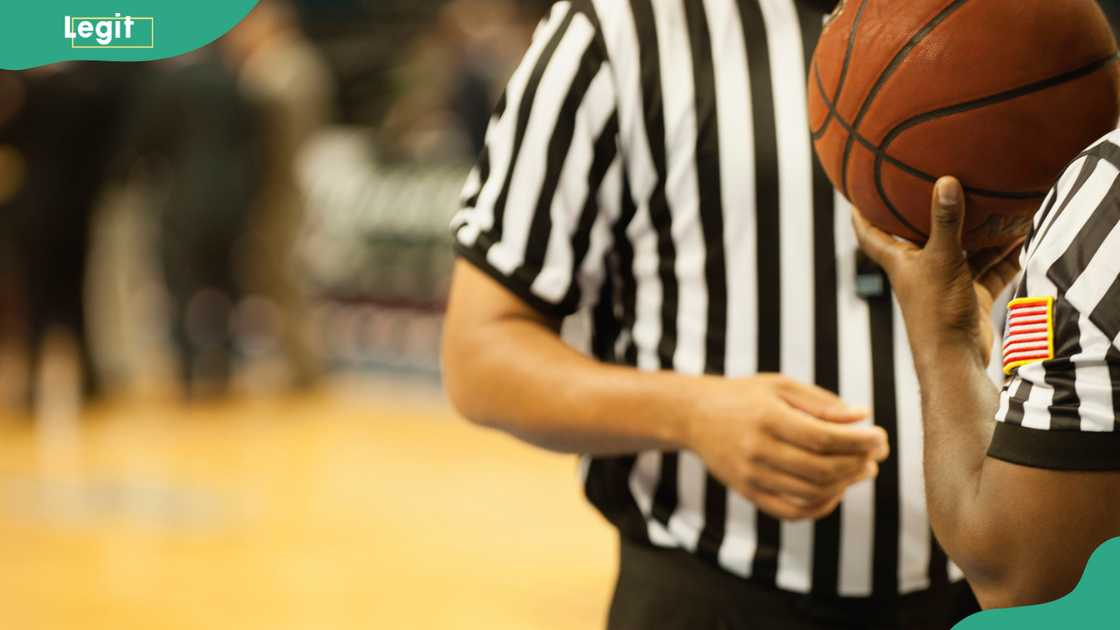 Basketball referees, with one holding a ball