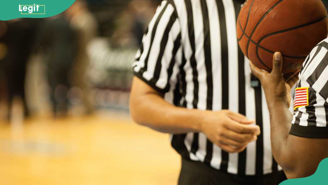 Basketball referees, with one holding a ball Basketball referees, with one holding a ball