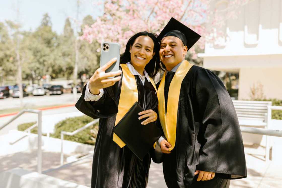 Smiling graduates taking selfie