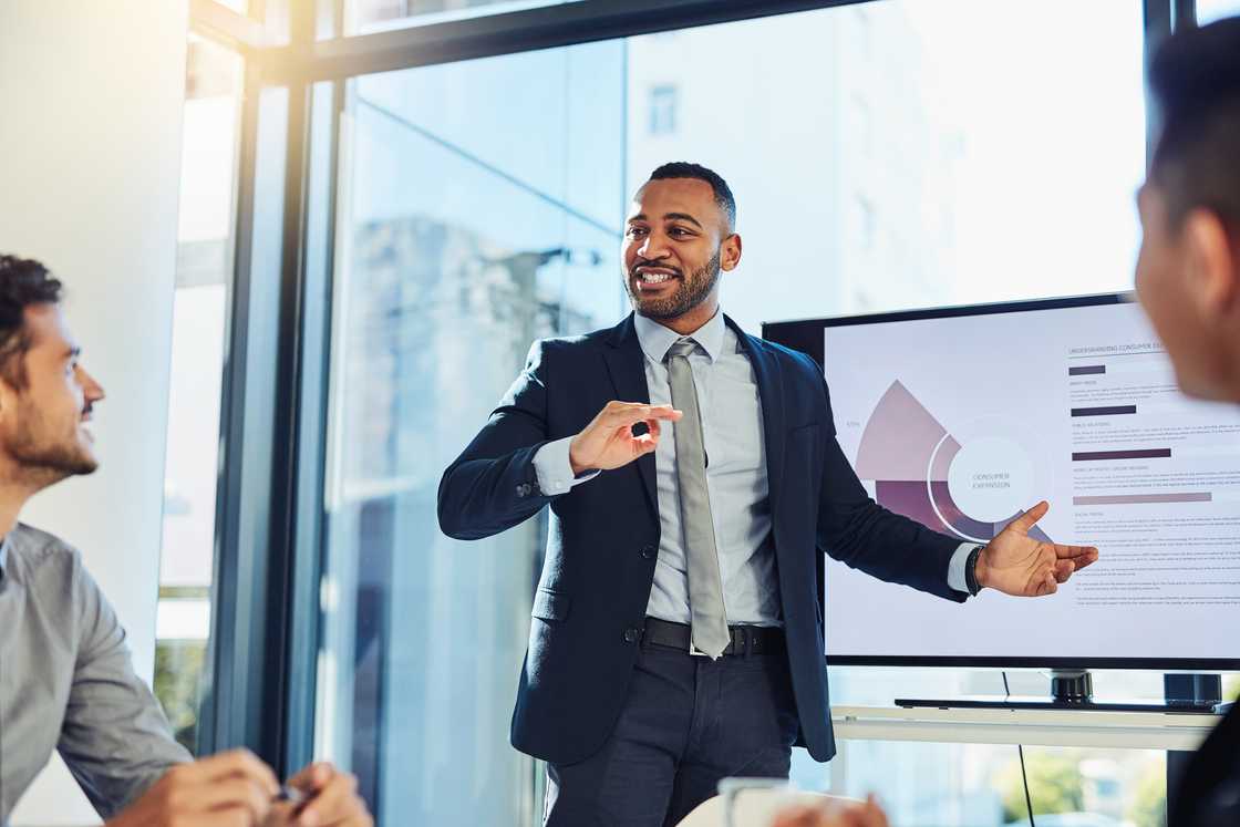 A young businessman delivering a presentation to his colleagues.