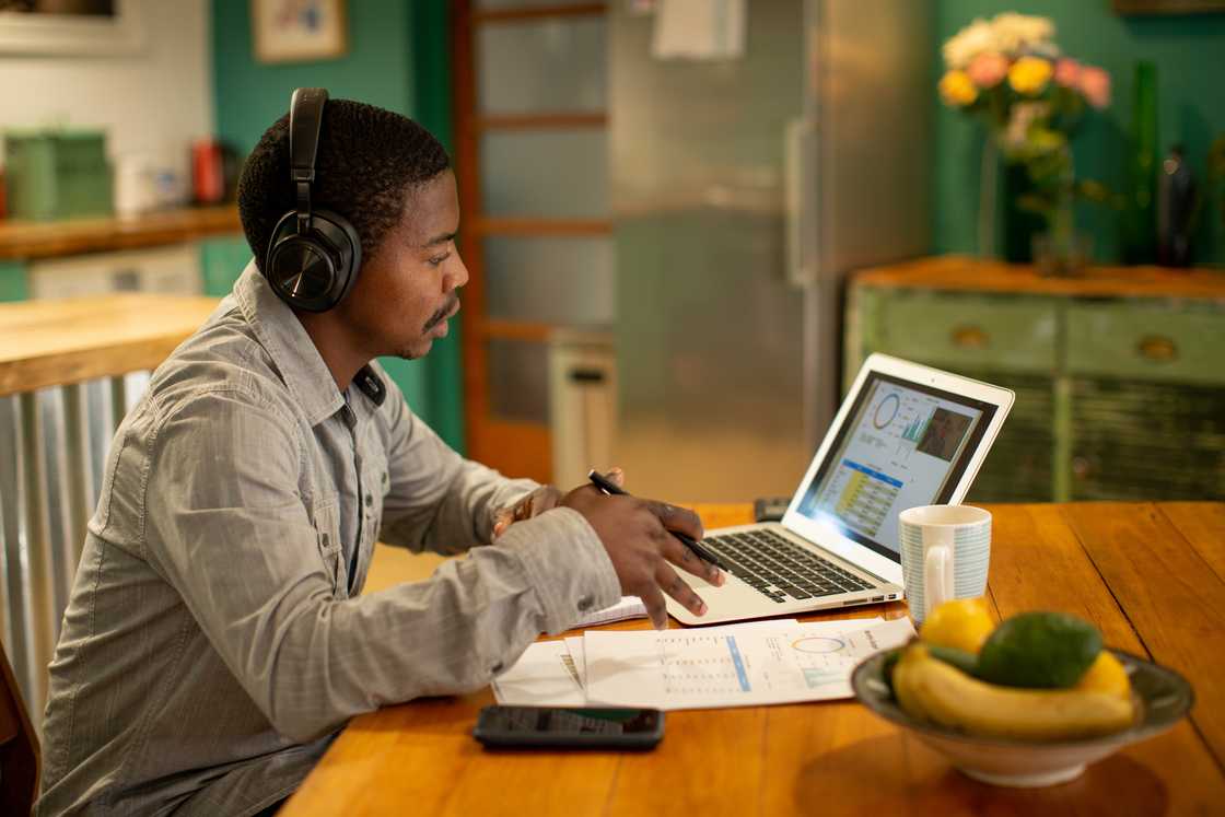A young man having a virtual meeting with his financial consultant from his own home.