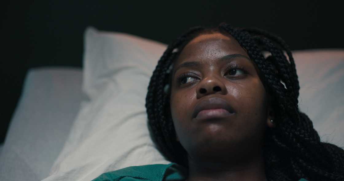 A woman lies awake thinking about her stokvel. A woman lies awake thinking about her stokvel.