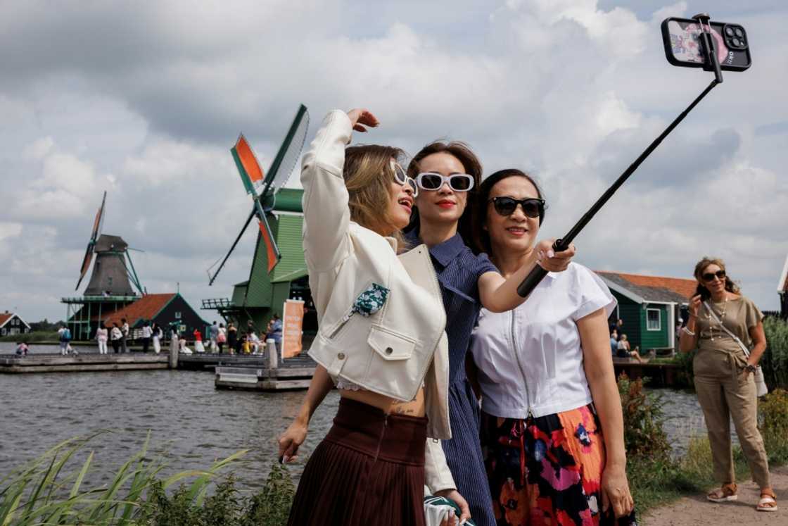 Tourists love to take selfies by windmills in Zaanse Schans Tourists love to take selfies by windmills in Zaanse Schans