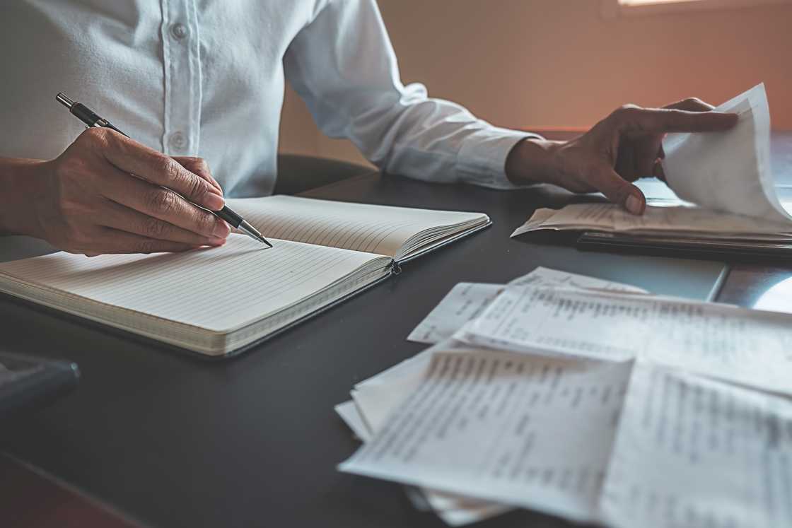An auditor reviews receipts and a ledger.