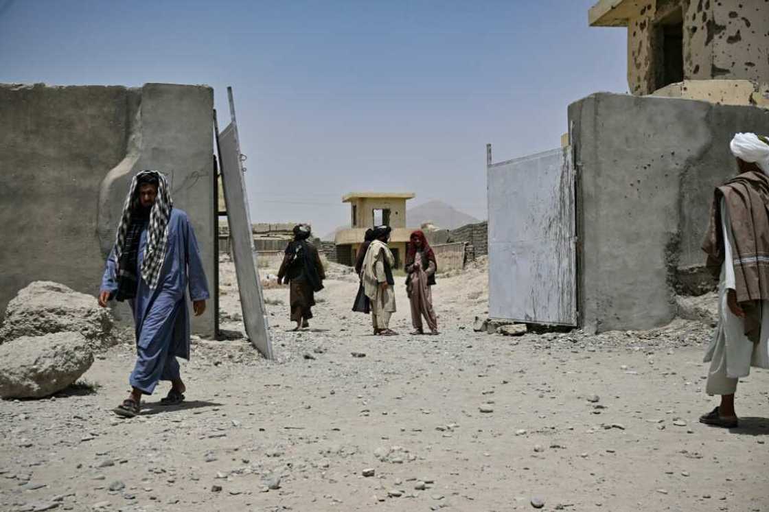 Afghans gather at the entrance of the ramshackle Musa Qala District Hospital in Helmand province in July 2022 amid widespread needs in the war-ravaged country again under Taliban rule