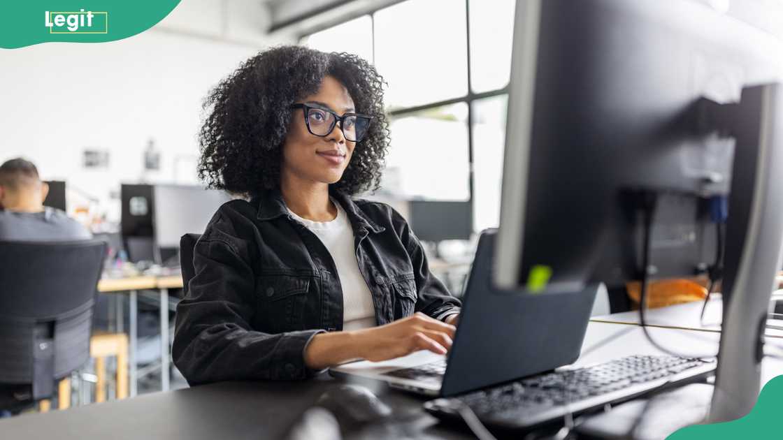 A female employee working on a computer at her workplace. A female employee working on a computer at her workplace.