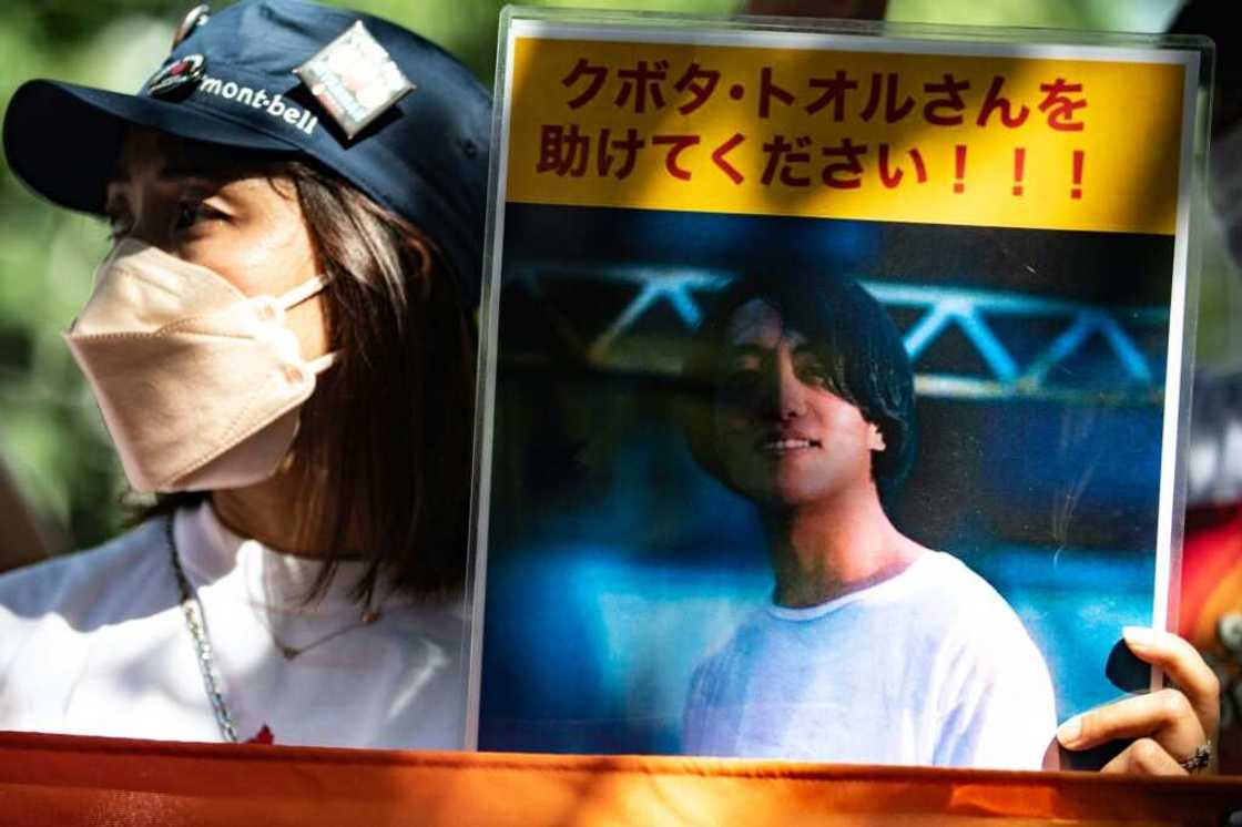 An activist in Tokyo holds a placard of Japanese journalist Toru Kubota, who is detained in Myanmar An activist in Tokyo holds a placard of Japanese journalist Toru Kubota, who is detained in Myanmar