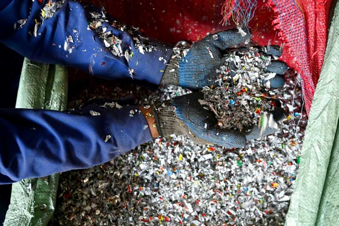 A worker sorts shredded recyclable plastic waste at the Green Road Waste Management processing facility in Pokhara