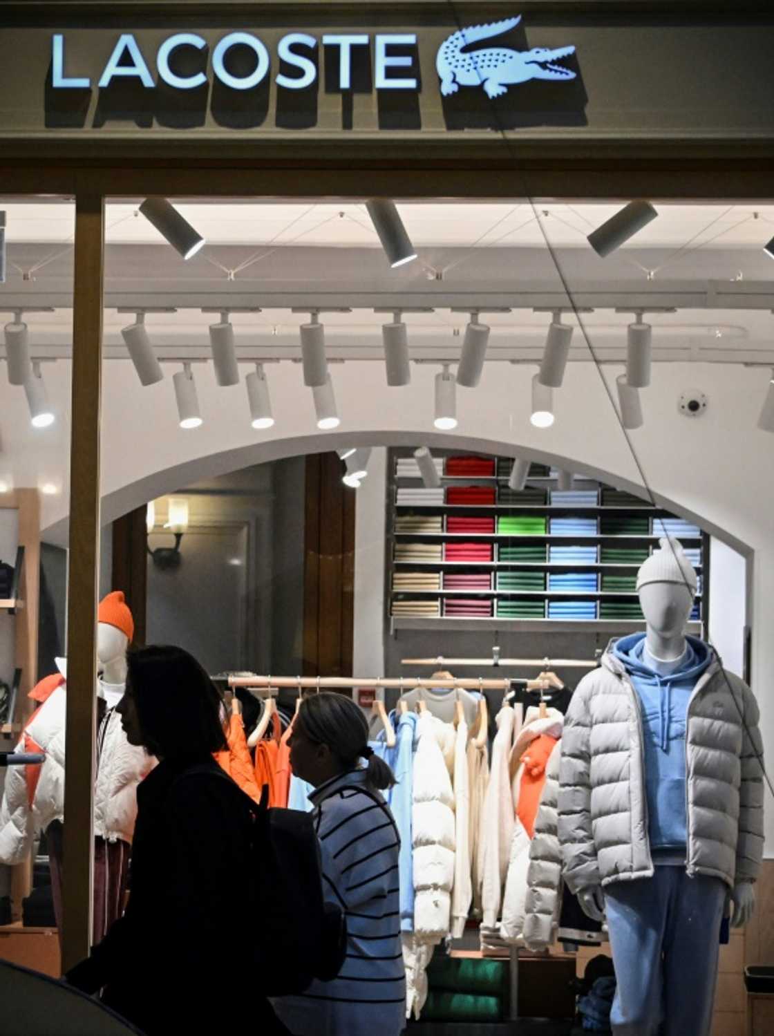 Customers walk past a French Lacoste shop at the GUM department store in Moscow Customers walk past a French Lacoste shop at the GUM department store in Moscow