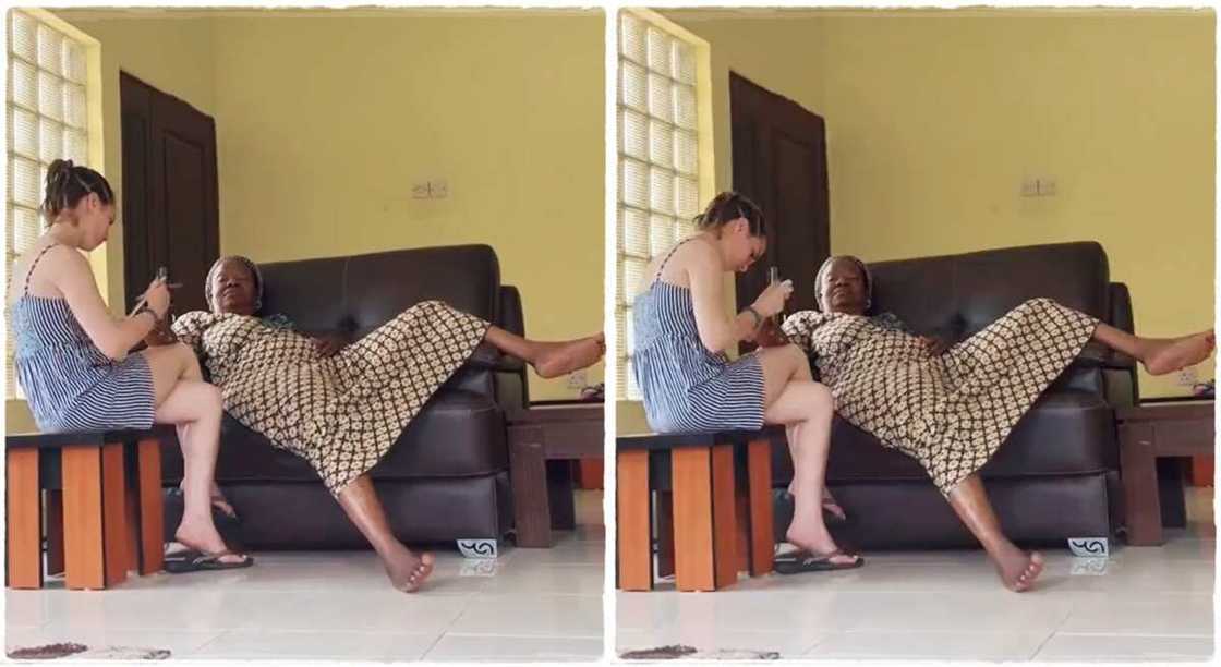 White woman cleans mother-in-law's nails.