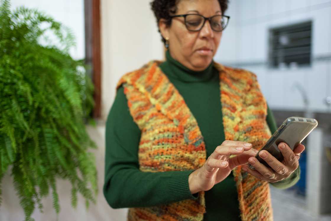 A senior woman uses a smartphone. A senior woman uses a smartphone.