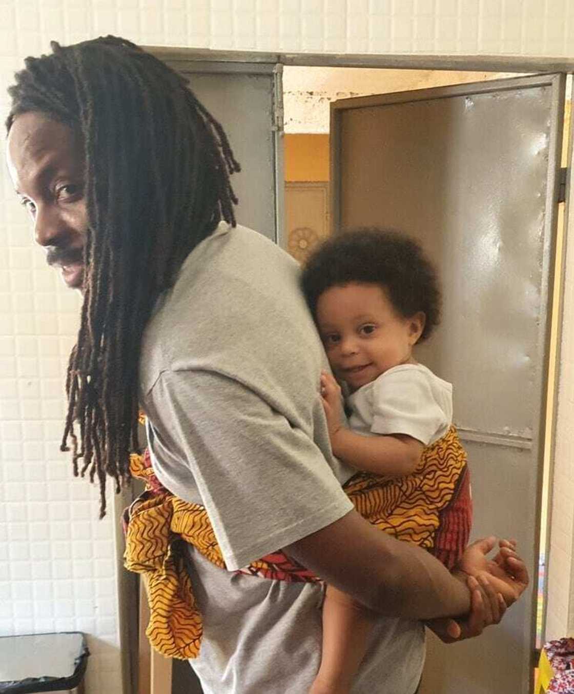 Working from home: Sierra Leone Minister feeds, carries 10-month-old daughter on his back during Zoom meeting Working from home: Sierra Leone Minister feeds, carries 10-month-old daughter on his back during Zoom meeting
